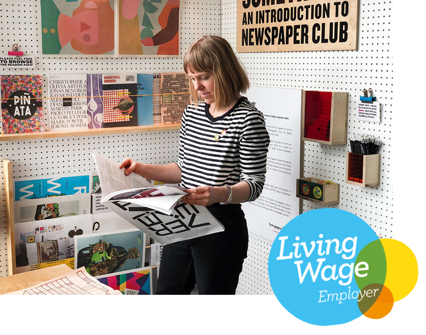 Lady reading newspapers in front of exhibition.