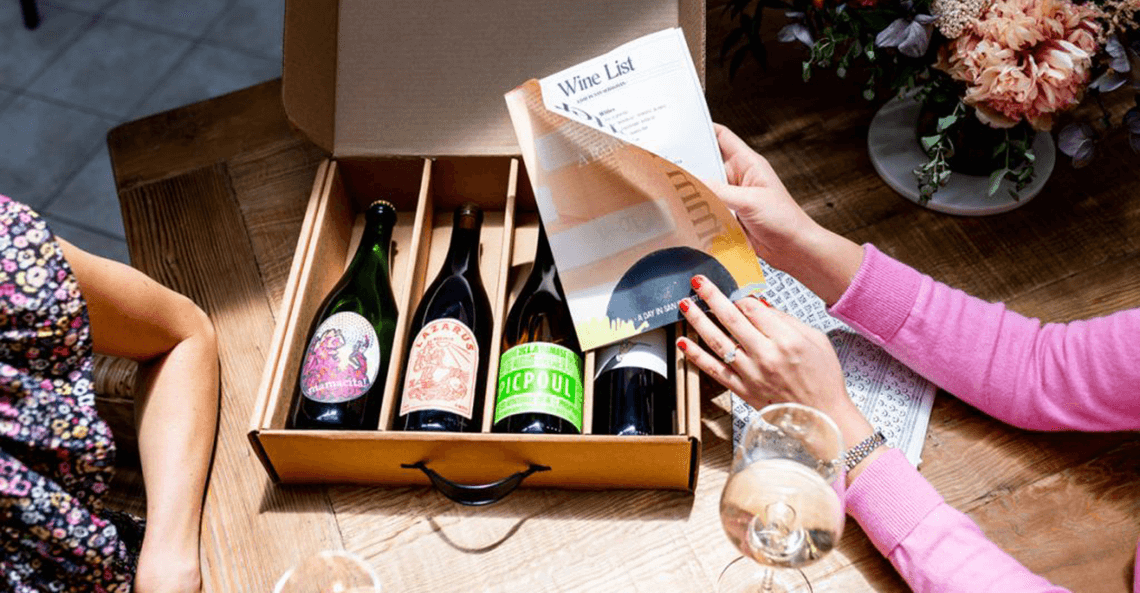 Lady with painted nails holds wine list printed on mini newspaper